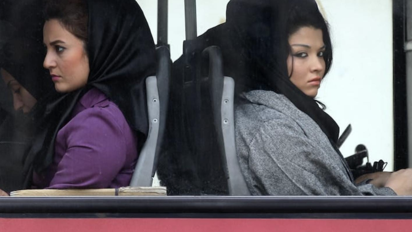 Iranian women look out from a bus