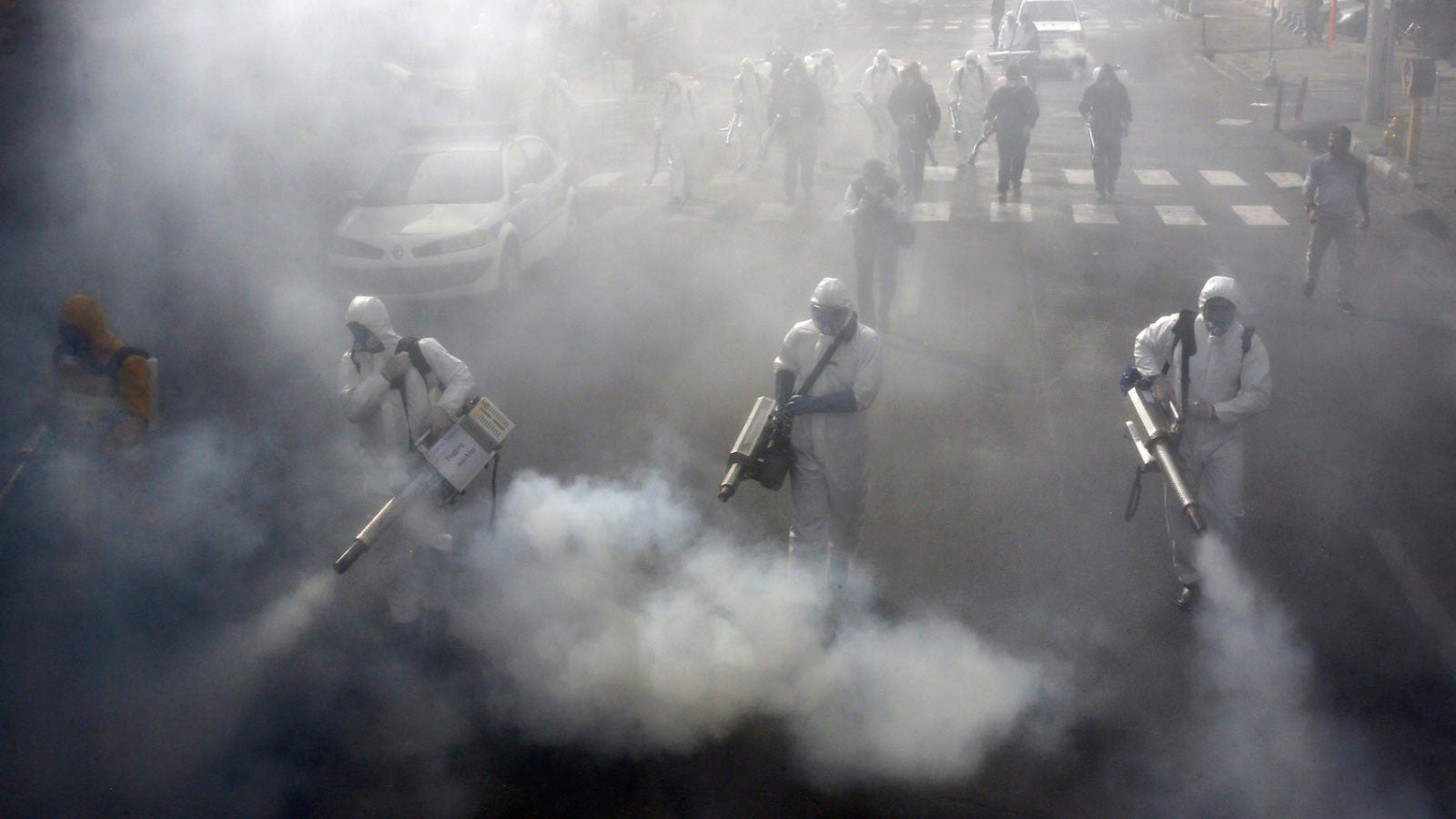 Iranian firefighters disinfect streets in Tehran in a bid to halt the spread of the coronavirus