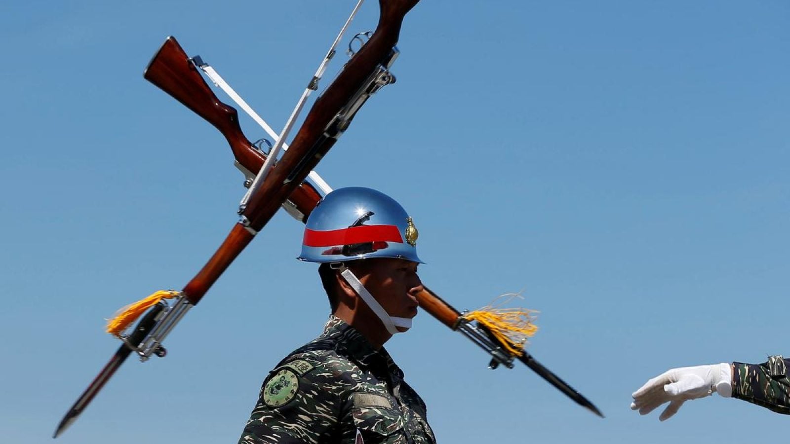 A Taiwanese soldier stands in front of two rifles during a military drill.