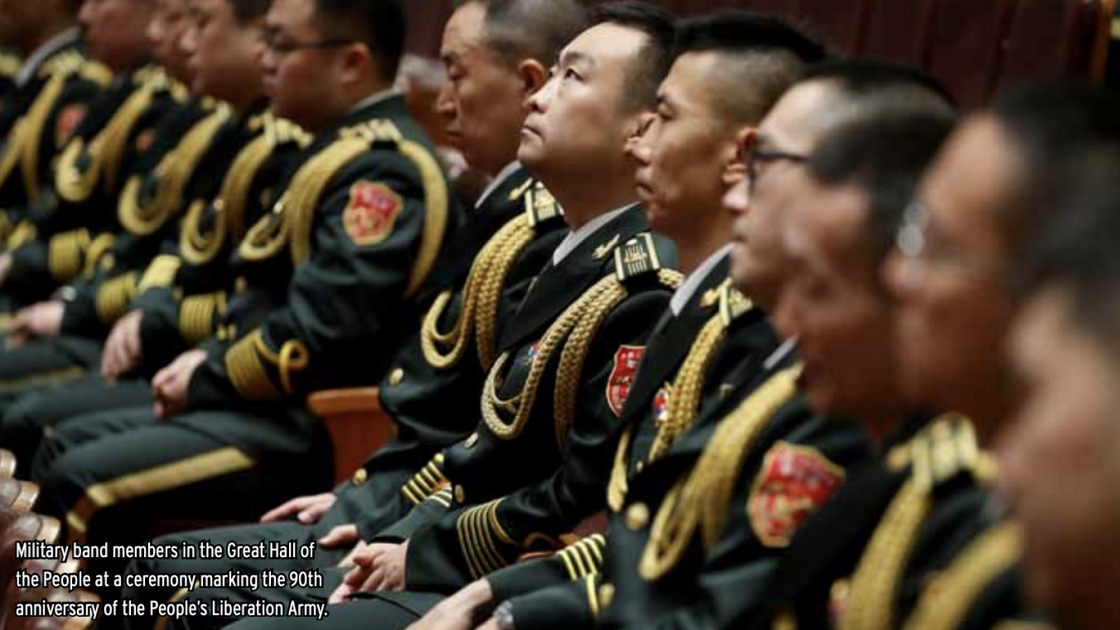 A row of Chinese military band members sit in uniform.