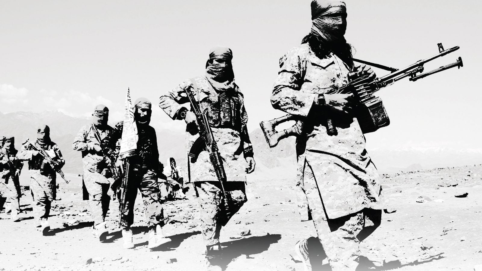 A black and white photograph of Taliban fighters carrying weapons and crossing a rocky terrain