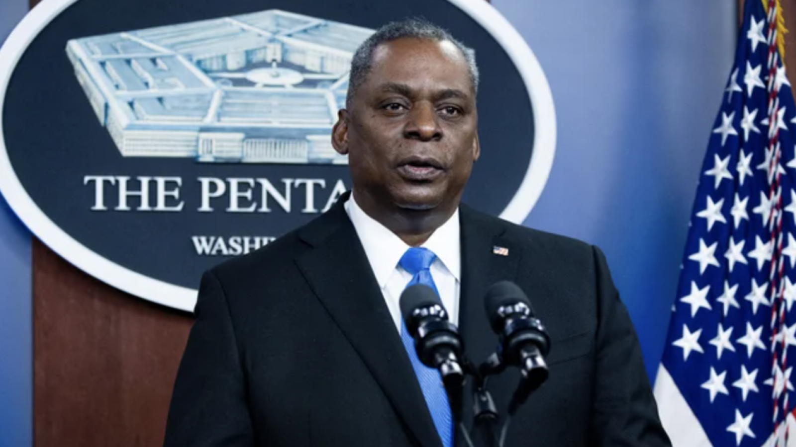 Secretary of Defense Lloyd Austin speaks at a podium in front of the Pentagon seal and an American flag